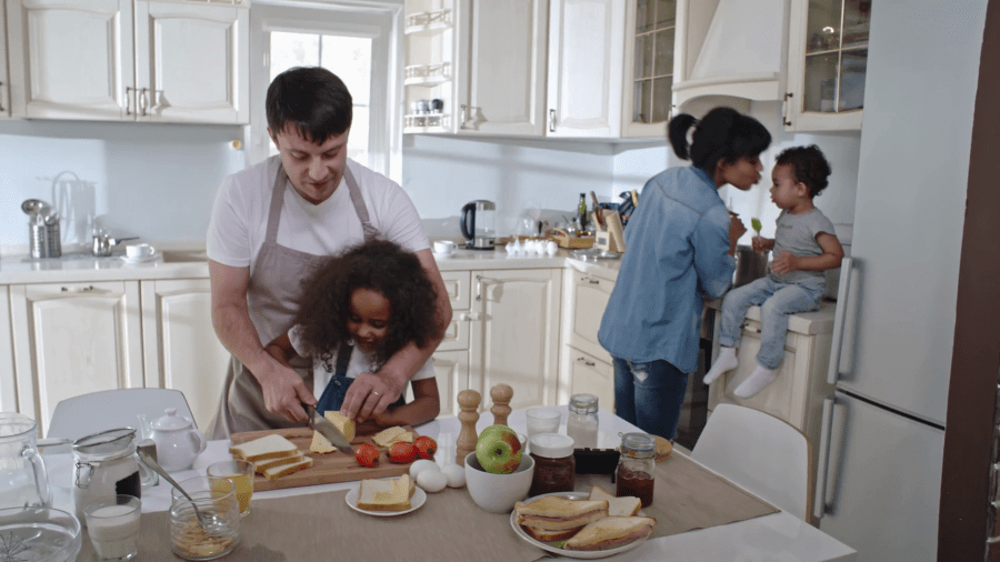 family-preparing-dinner-together-father-teaching-little-daughter-how-to-slice-cheese-while-mom-cooking-on-stove-with-baby-son_hi8lbebme_thumbnail-full01